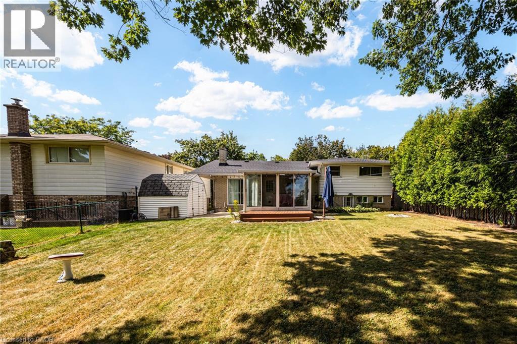Expansive backyard with a wooden deck, mature perimeter trees, and a storage shed - 2037 Mountain Grove Avenue, Burlington, ON