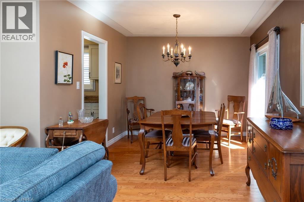 Wood-finish flooring throughout, with a classic chandelier and crown molding - 78 Berkley Crescent, Simcoe, ON