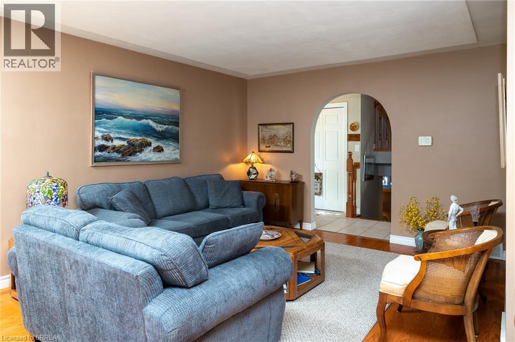 Arched doorway entry to an interior space, with wood-finish flooring, and a neutral wall color - 78 Berkley Crescent, Simcoe, ON