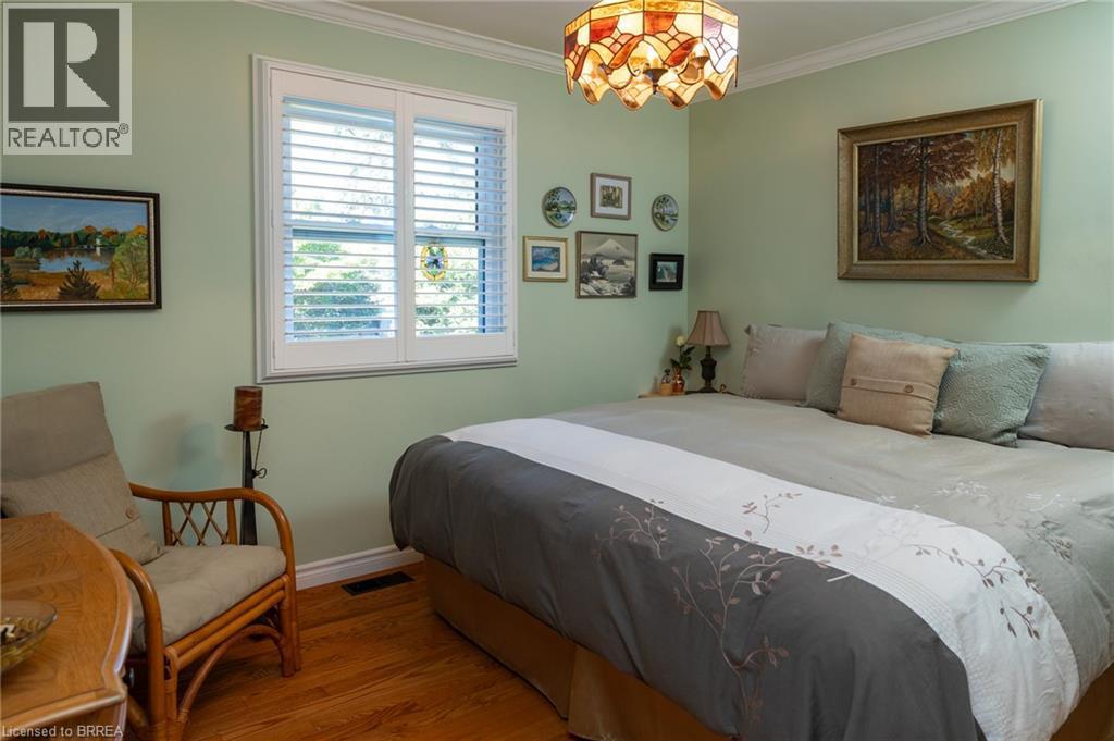 Hardwood flooring, crown molding, window with plantation shutters, ceiling-mounted stained glass light fixture, wall-mounted artwork - 78 Berkley Crescent, Simcoe, ON
