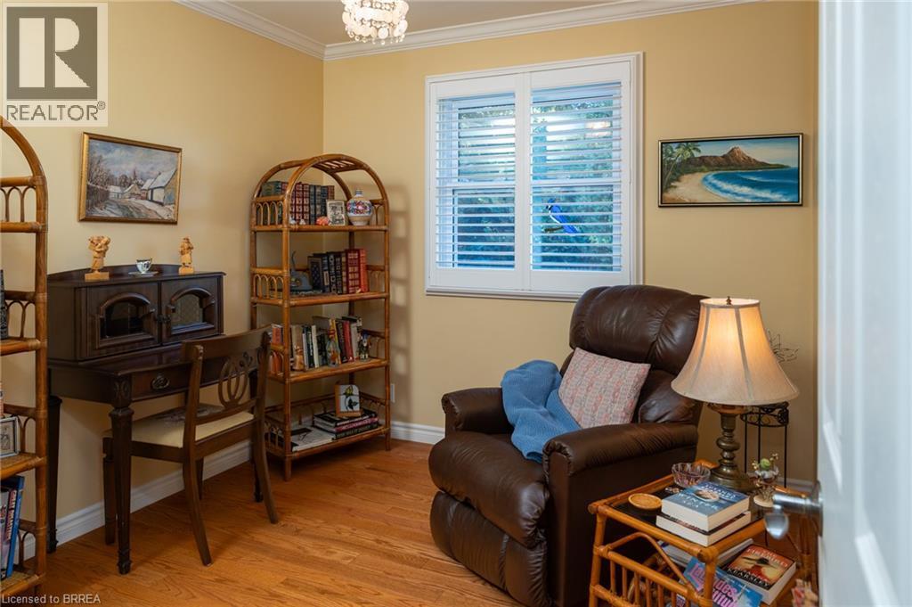 Wood-finish flooring, crown molding, and a built-in window with white plantation shutters - 78 Berkley Crescent, Simcoe, ON