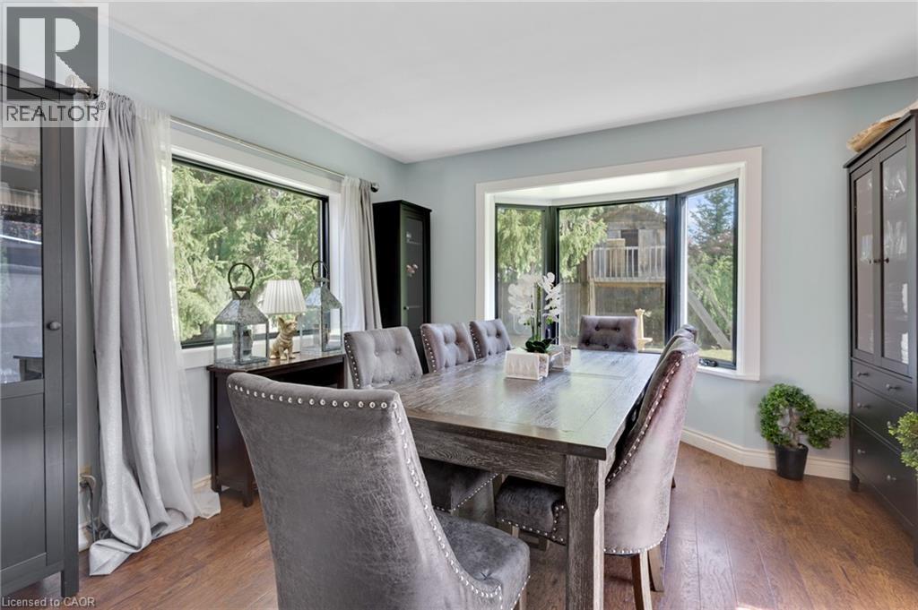 Hardwood-finish flooring, two large windows, and a bay window featuring a white trim - 7 Shadywood Lane, Cambridge, ON