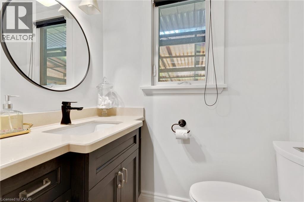 Dark wood-finish vanity with an integrated sink and light-toned countertop - 7 Shadywood Lane, Cambridge, ON