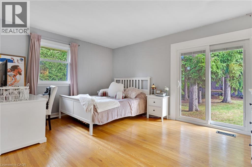 Hardwood flooring, sliding glass door, white trim, single window, and light grey wall paint - 7 Shadywood Lane, Cambridge, ON