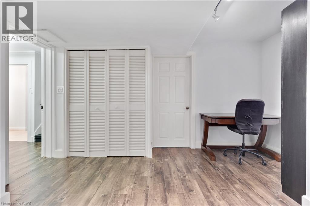 Wood-finish flooring with white louvered bifold closet doors and track lighting - 7 Shadywood Lane, Cambridge, ON