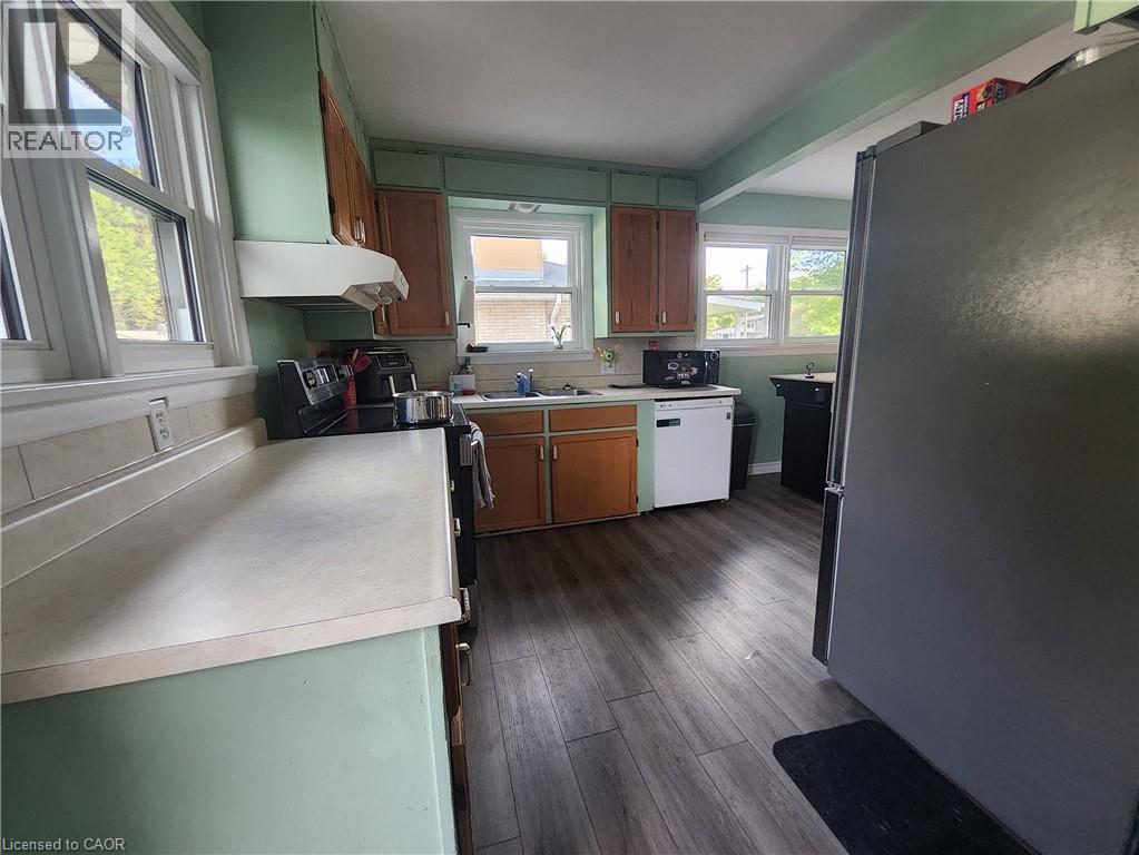 Wood-finish flooring, multiple windows, built-in cabinetry, and a range hood - 33 Lee Avenue, Simcoe, ON