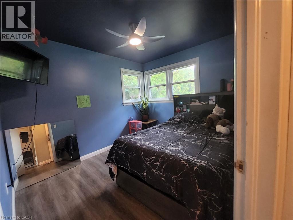 Wood-finish flooring, corner windows, ceiling fan with integrated lighting, and a built-in headboard storage unit - 33 Lee Avenue, Simcoe, ON
