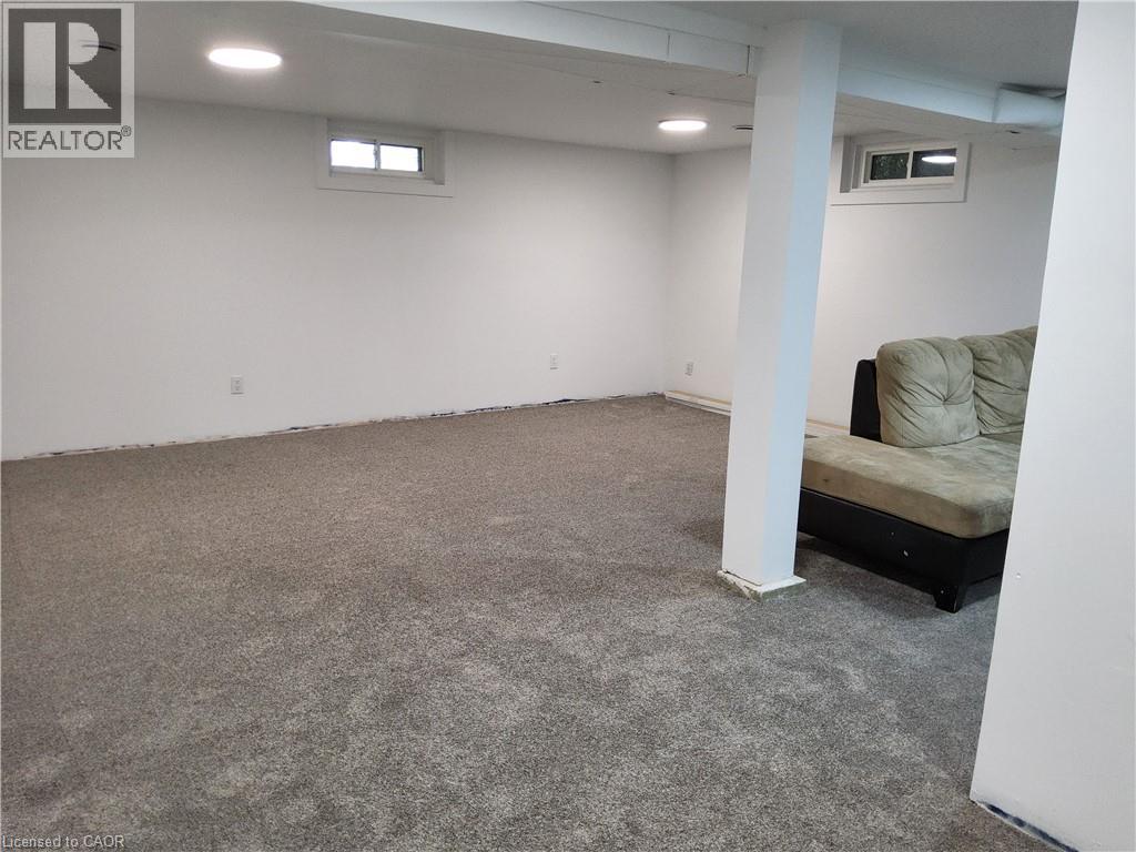 Recessed lighting, painted white walls, gray carpet, and two egress windows - 33 Lee Avenue, Simcoe, ON