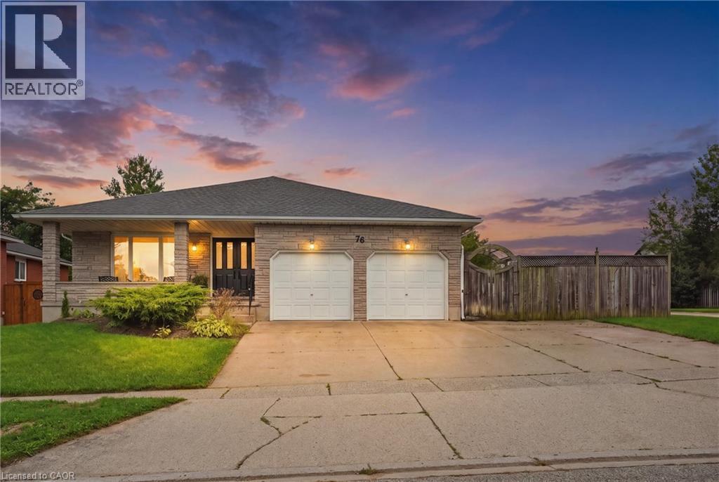 Stone facade with an asphalt shingle roof, featuring an attached two-car garage, covered entry, and a manicured front lawn - 76 Madeira Crescent, Cambridge, ON