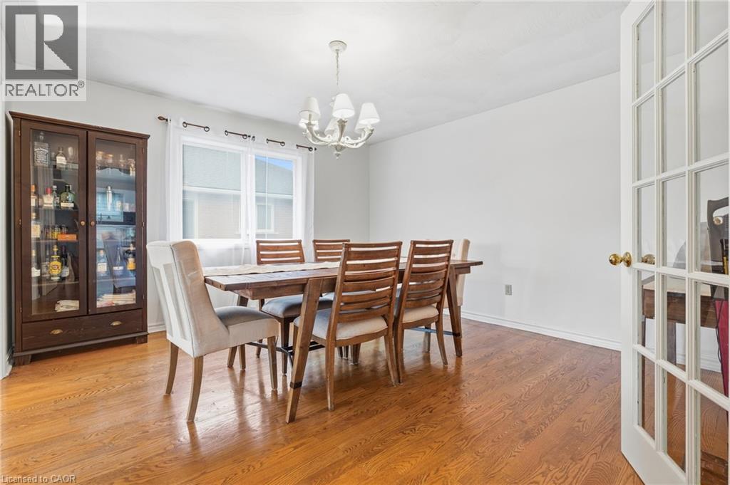 Hardwood-finish flooring throughout, featuring a multi-pane window and a chandelier light fixture - 76 Madeira Crescent, Cambridge, ON