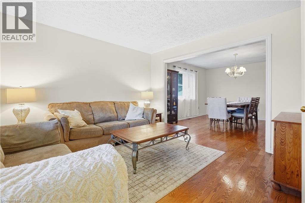 Hardwood flooring throughout, neutral paint palette, and a cased opening to the dining area - 76 Madeira Crescent, Cambridge, ON