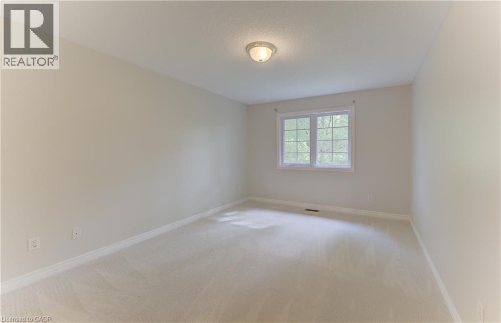 Recessed window with white trim, light-toned carpeting, and a flush-mount ceiling light fixture (NEW CARPET) - 25 Bankside Drive Unit# 2, Kitchener, ON