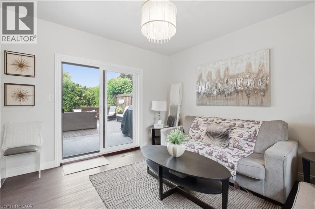Wood-finish flooring, sliding glass patio doors, and a decorative ceiling fixture - 22 Sycamore Street, Hamilton, ON