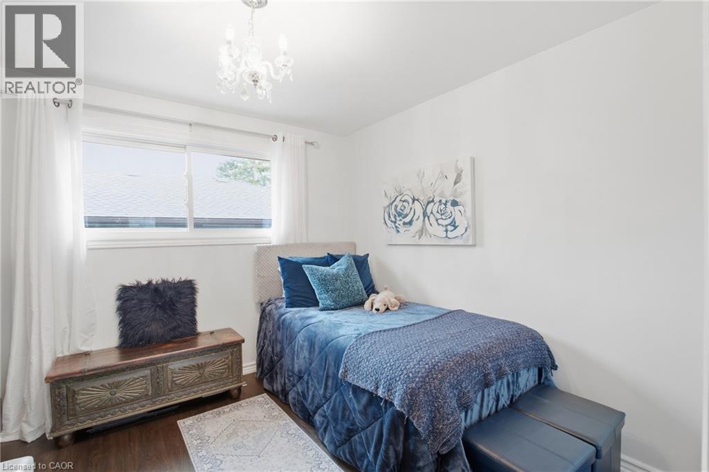 Hardwood-style flooring, white walls, and a decorative chandelier - 22 Sycamore Street, Hamilton, ON