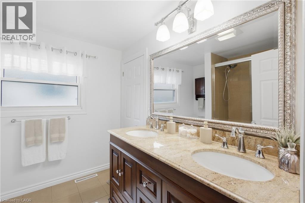 Dual vanity featuring undermount sinks, chrome fixtures, and a light-toned countertop - 22 Sycamore Street, Hamilton, ON