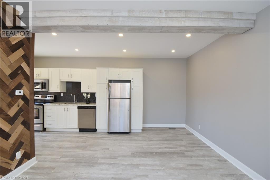 Kitchen featuring white cabinetry, stainless steel appliances, and light-colored countertops - 76 Burlington Street E, Hamilton, ON