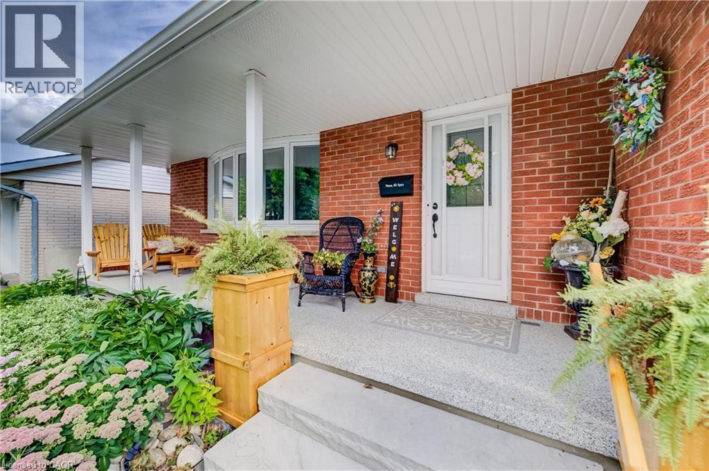 Brick exterior with white trim, covered front porch, concrete steps, and a bay window - 422 Grangewood Drive, Waterloo, ON
