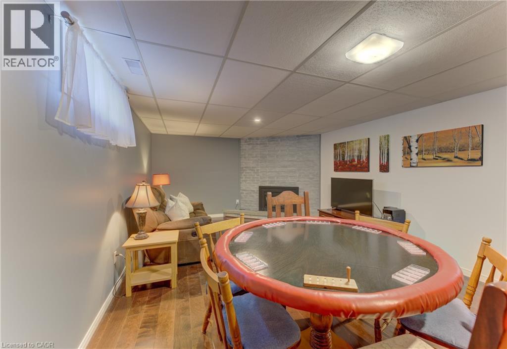 Wood-finish flooring throughout, featuring a stone-clad fireplace and recessed lighting - 422 Grangewood Drive, Waterloo, ON