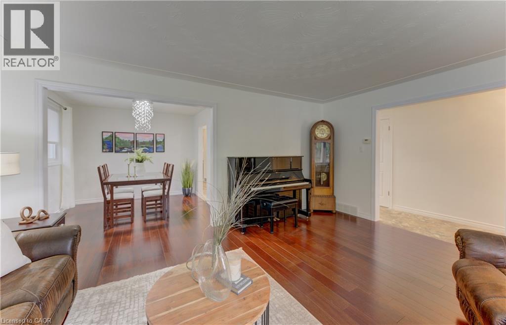 Rich wood-finish flooring extends through the main living areas, complemented by white walls and trim - 422 Grangewood Drive, Waterloo, ON