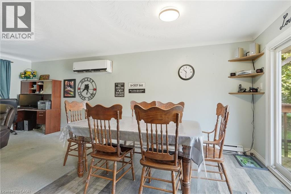 Wood-finish flooring, wall-mounted air conditioning unit and exterior access via sliding glass door - 1311 W Concession 6 Road, Flamborough, ON