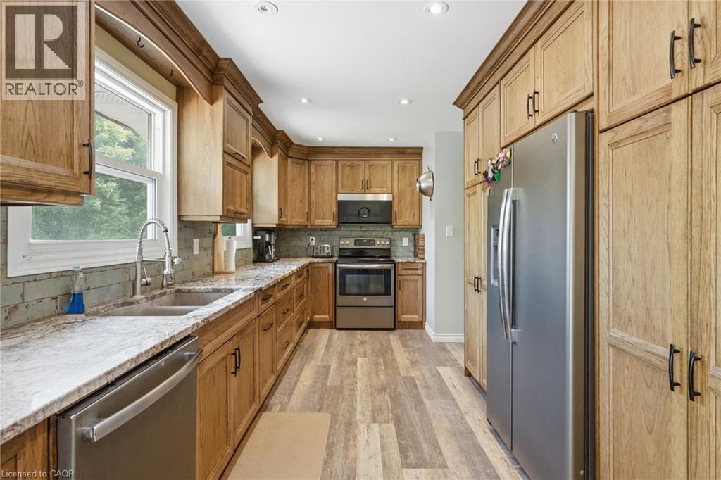 Kitchen featuring light wood-finish cabinetry, stainless steel appliances, light-toned countertops, tile backsplash, and recessed lighting - 1311 W Concession 6 Road, Flamborough, ON