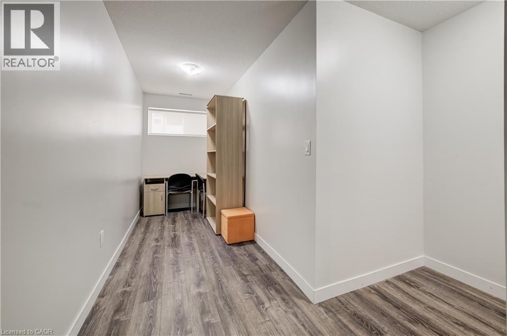 Wood-finish flooring, white walls, and a single window offering natural light - 338 Albert Street Unit# 114, Waterloo, ON