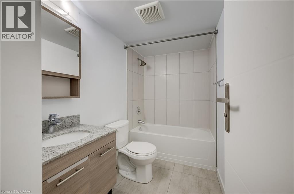 Light-toned wood-finish vanity with a mounted sink and stone countertop - 338 Albert Street Unit# 114, Waterloo, ON
