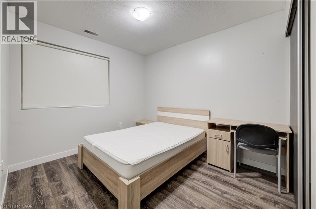 Wood-finish flooring, white walls, and a window with a roller shade - 338 Albert Street Unit# 114, Waterloo, ON