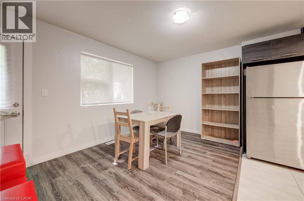 Wood-finish flooring, white walls, and a window with a roller shade - 338 Albert Street Unit# 114, Waterloo, ON