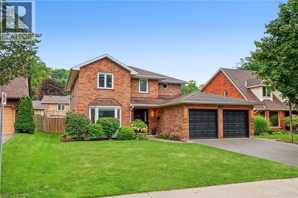 Brick two-story exterior with a bay window, asphalt shingle roof, and an attached two-car garage - 141 Race Street, Paris, ON