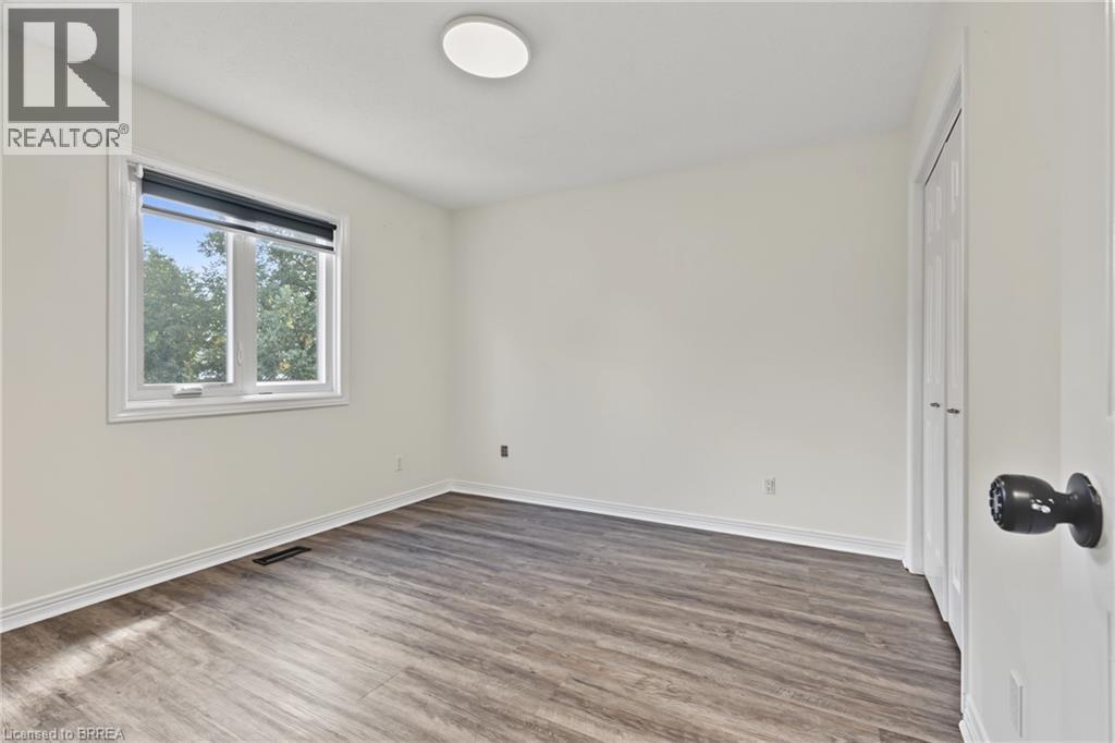 White walls, wood-finish flooring, and a flush mount ceiling light - 141 Race Street, Paris, ON