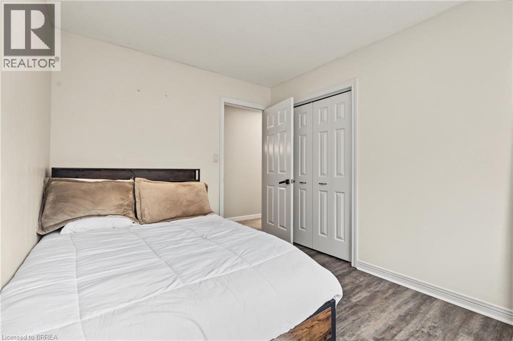 Wood-finish flooring, white walls, and a bi-fold closet door - 141 Race Street, Paris, ON