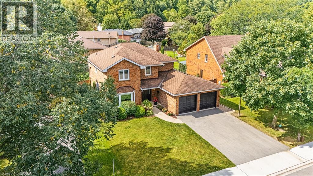 Brick exterior residence featuring a two-car garage, bay window, paved driveway, and established landscaping - 141 Race Street, Paris, ON