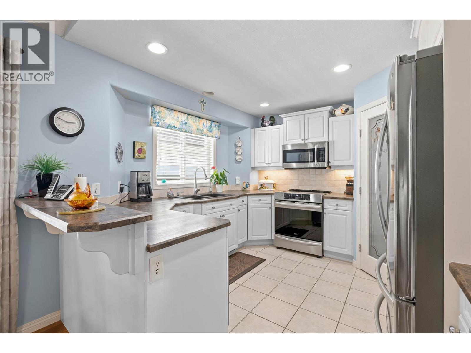 Spacious kitchen with abundant cabinetry, pantry, and stainless steel appliances. - 1188 Houghton Road Unit# 122, Kelowna, BC