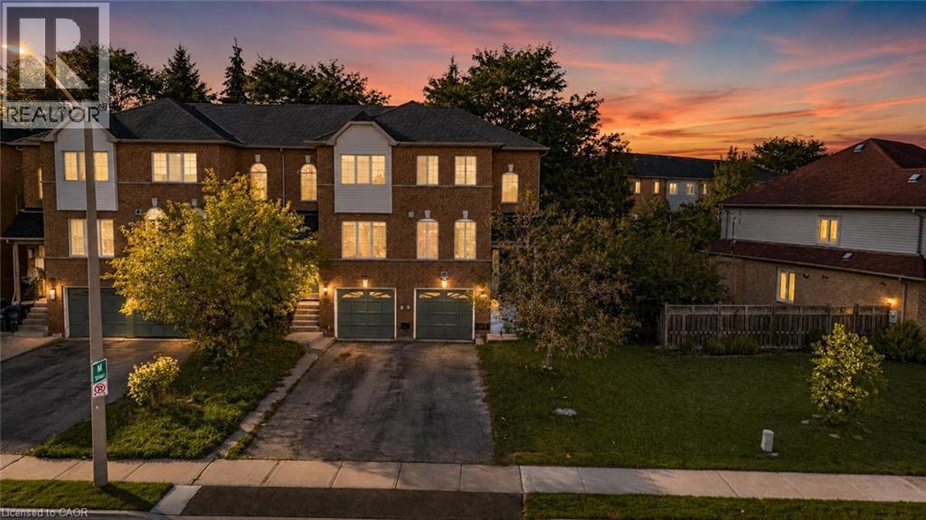 Brick facade exterior with multiple window styles, integrated garages, and a front lawn - 123 Brickyard Way, Brampton, ON