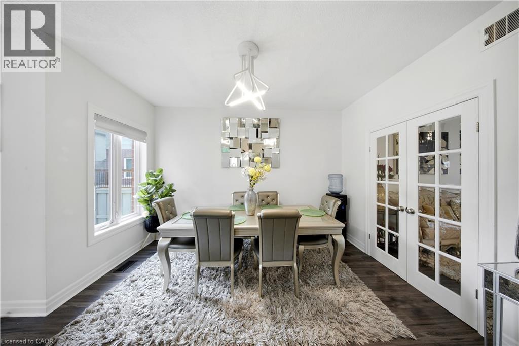 Wood-finish flooring, white walls, and a large window with roller shade - 167 Broadoaks Drive, Cambridge, ON