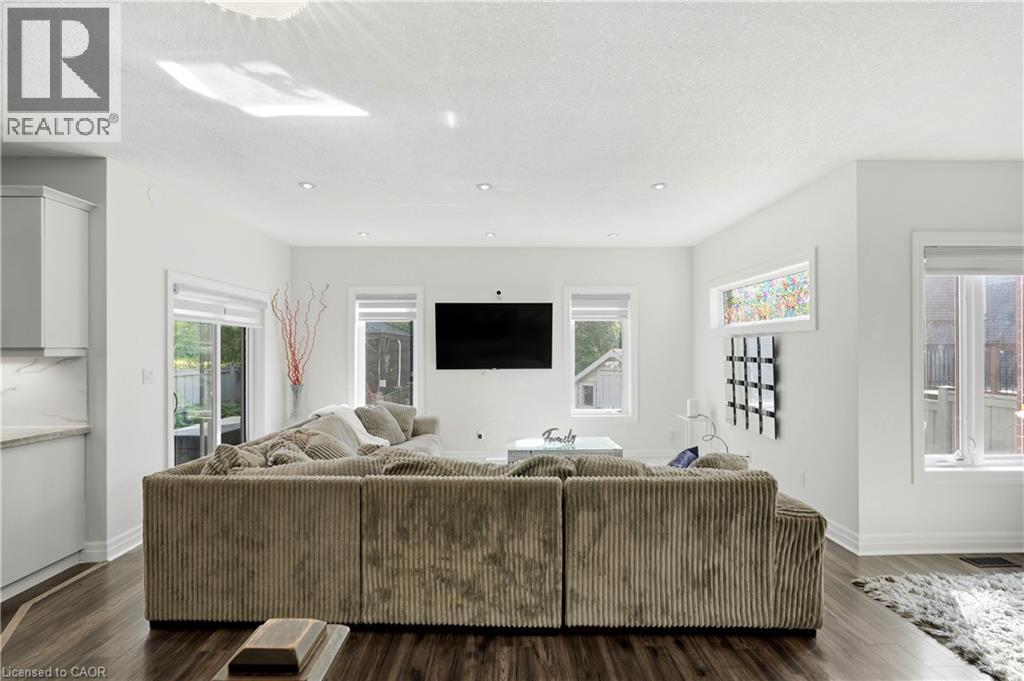 Recessed ceiling lighting, wood-finish flooring, white cabinetry with under-cabinet lighting, and a sliding glass door - 167 Broadoaks Drive, Cambridge, ON
