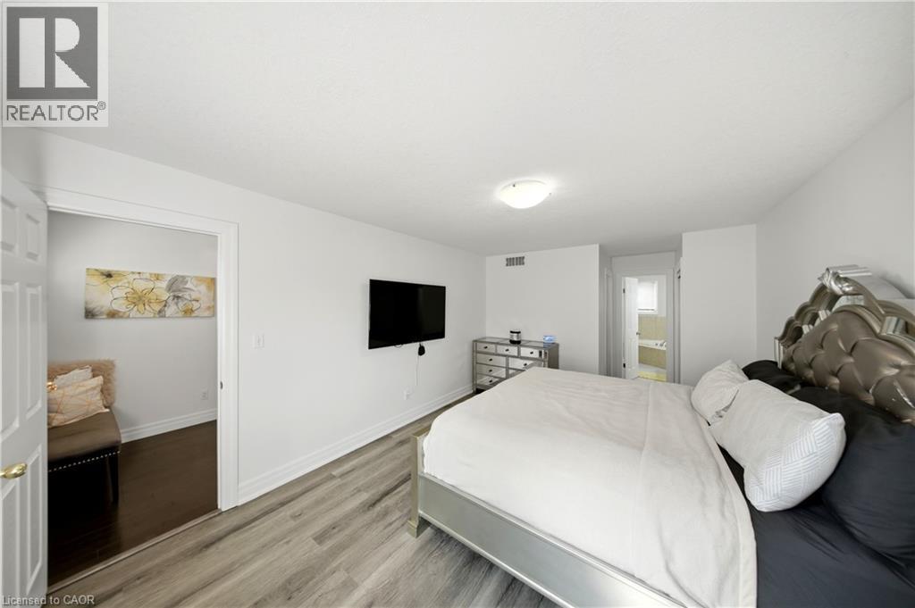 Light wood-finish flooring, white walls, and a ceiling-mounted light fixture - 167 Broadoaks Drive, Cambridge, ON
