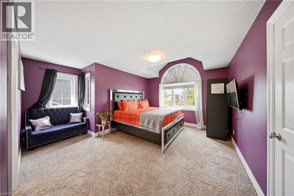 Carpeted room featuring a large arched window with horizontal blinds, additional window, and a built-in ceiling light fixture - 167 Broadoaks Drive, Cambridge, ON