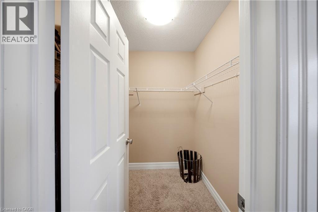 Walk-in closet featuring wire shelving, neutral carpeting, and a flush mount ceiling light - 167 Broadoaks Drive, Cambridge, ON