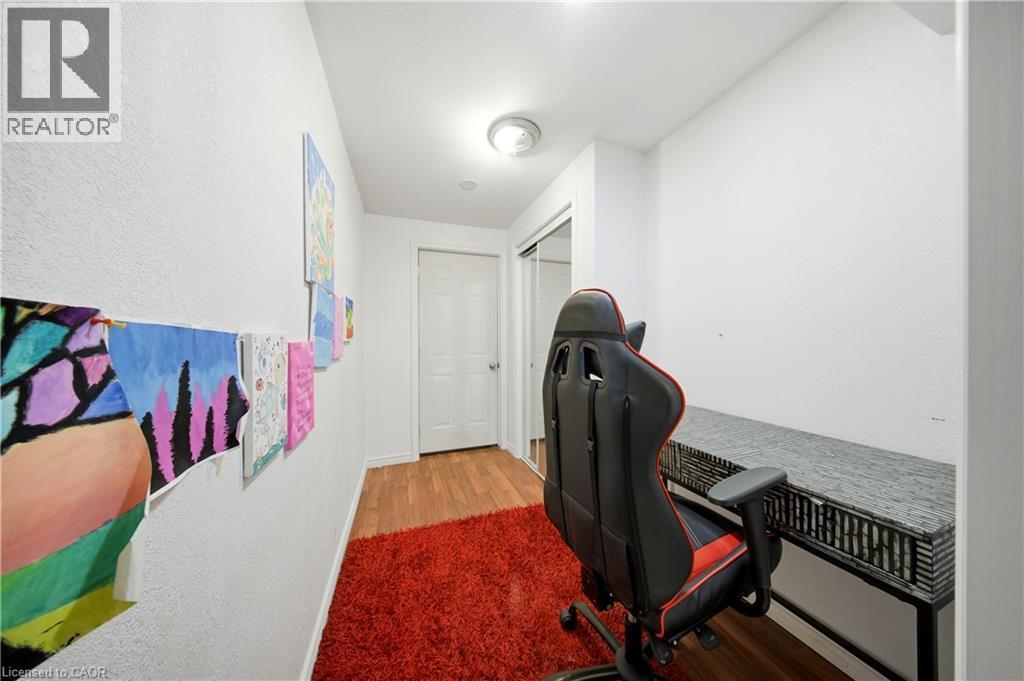 Wood-finish flooring, white walls, and a built-in desk area with a sliding closet - 167 Broadoaks Drive, Cambridge, ON