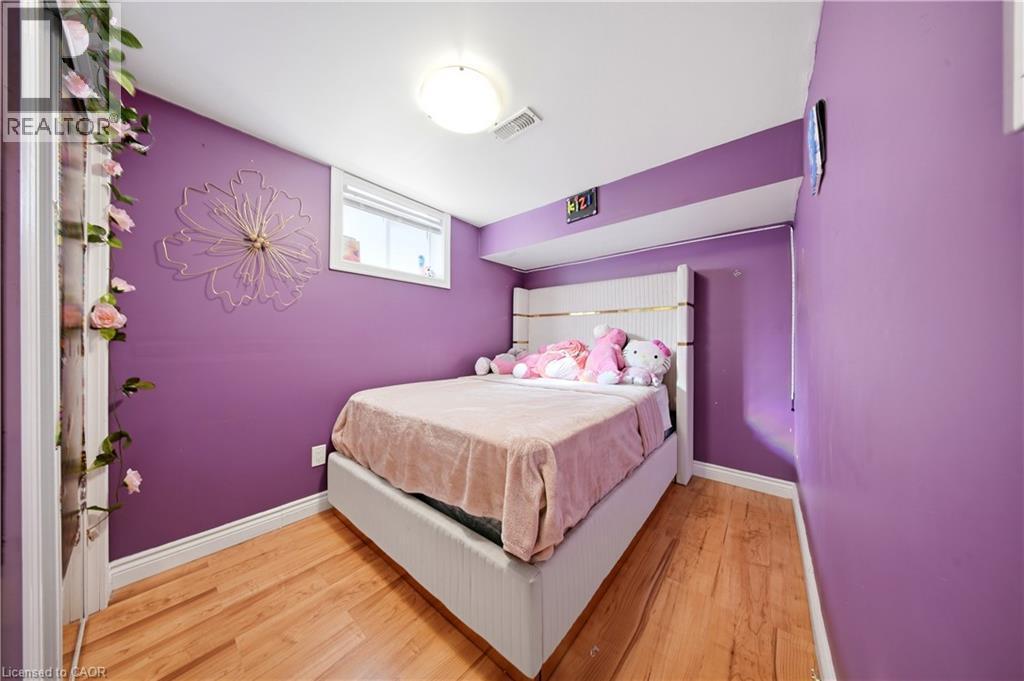 Wood-finish flooring throughout, white trim, and a window with blinds - 167 Broadoaks Drive, Cambridge, ON