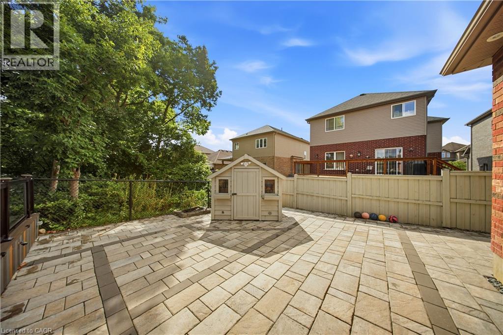 Expansive patio featuring multi-toned paver stones and a decorative border - 167 Broadoaks Drive, Cambridge, ON
