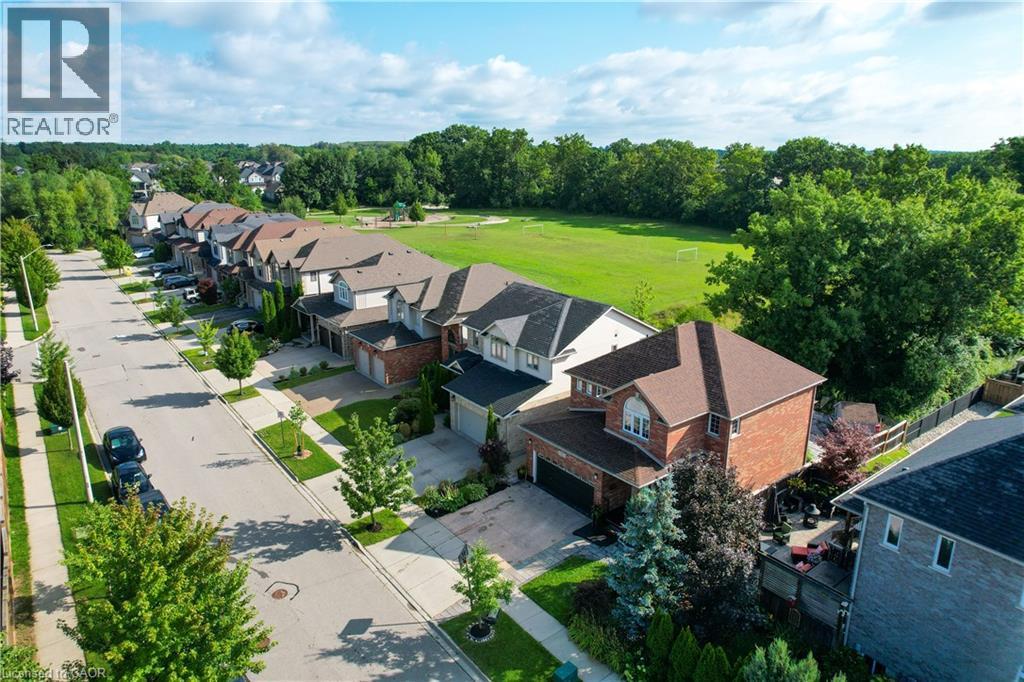Residential street with detached homes, mature trees, sidewalks, and a large green space - 167 Broadoaks Drive, Cambridge, ON