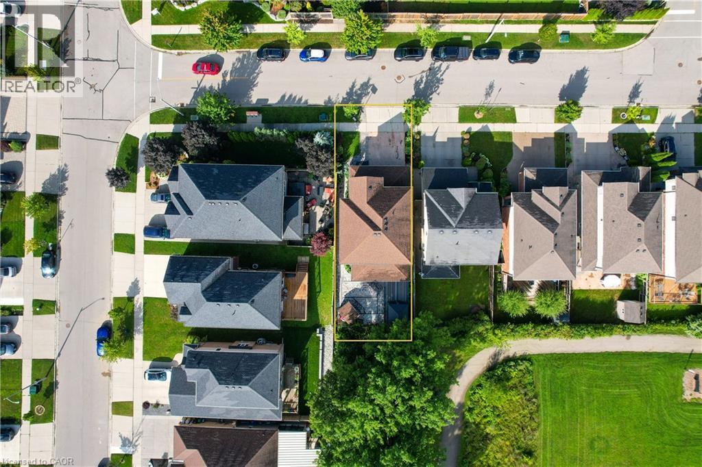 Residential property featuring a private backyard, mature trees, adjacent green space, and proximity to paved roadways - 167 Broadoaks Drive, Cambridge, ON