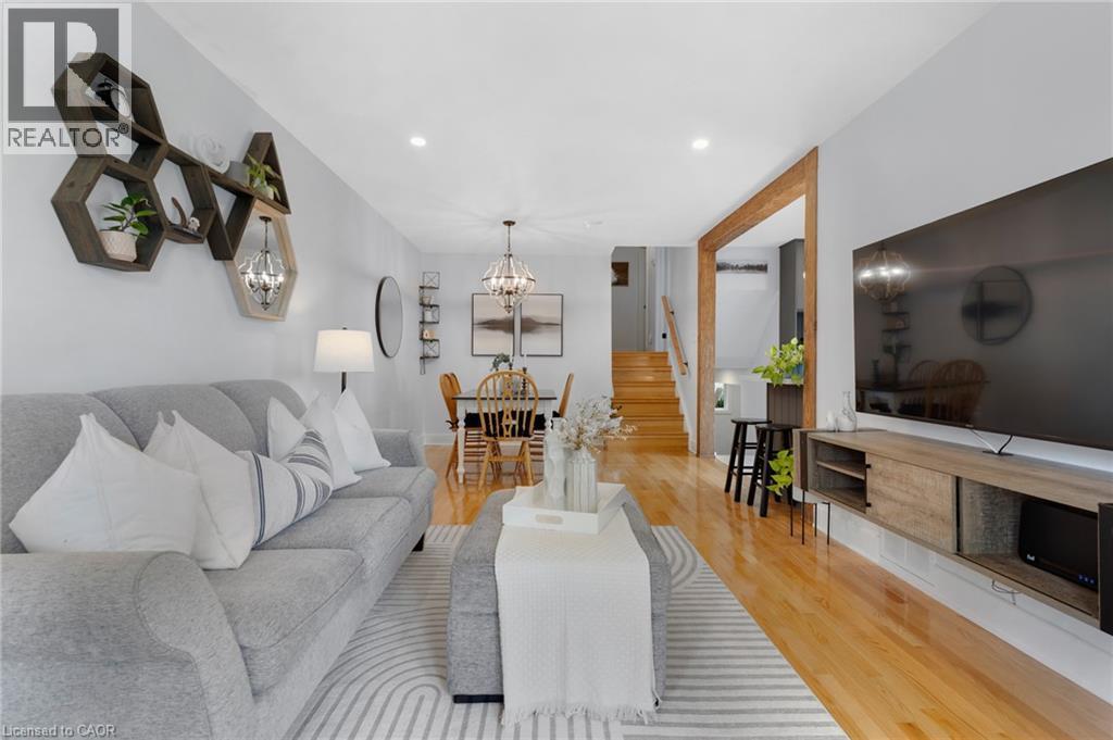 Recessed ceiling lighting, wood-finish flooring, a wood accent doorway, and a built-in media console - 477 Kingscourt Drive Unit# B, Waterloo, ON