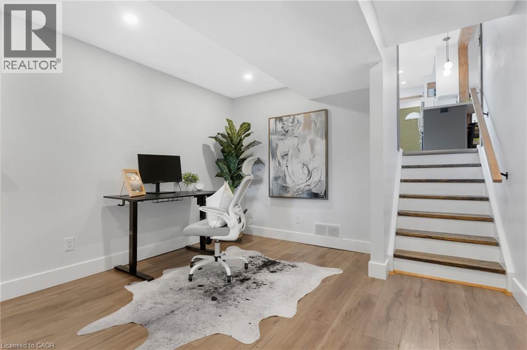 Recessed ceiling lighting, light wood-finish flooring, white baseboards, and a natural wood staircase with a black handrail - 477 Kingscourt Drive Unit# B, Waterloo, ON