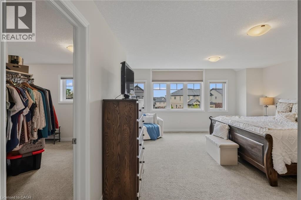 Spacious room featuring light-colored carpeting, multiple windows with roller shades, and a ceiling-mounted light fixture - 249 Woodway Trail, Simcoe, ON