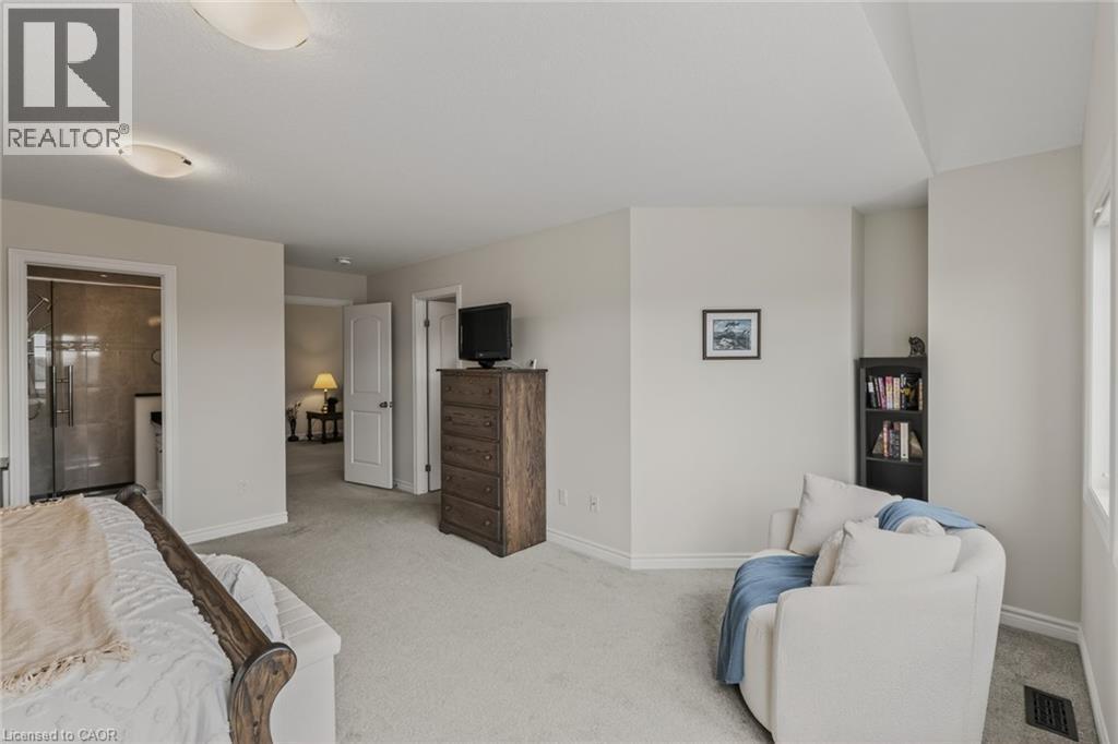 Carpeted bedroom featuring a wood bed frame and a semi-flush mount ceiling light - 249 Woodway Trail, Simcoe, ON