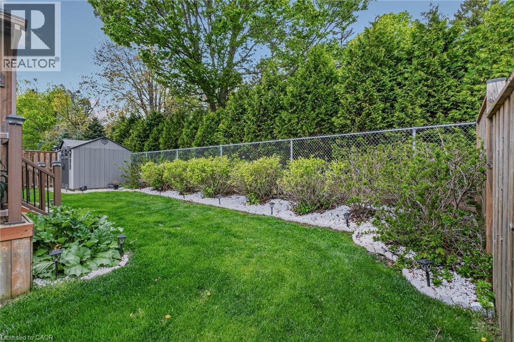 Expansive lawn area featuring a decorative gravel border with shrubbery - 249 Woodway Trail, Simcoe, ON